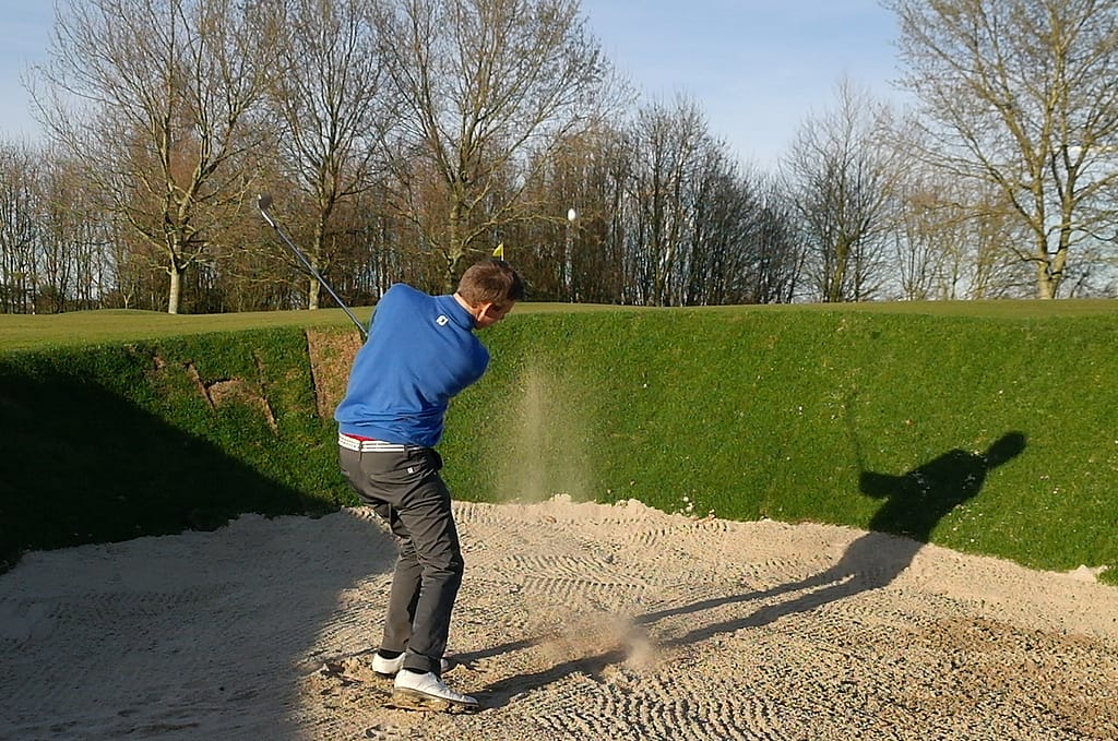 PGA golfprofessional Patrique Baljé slaat de bal uit een bunker